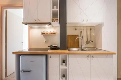 a small kitchen with white cabinets and a sink at Stone house near Acropolis - Living Stone Diamond in Athens