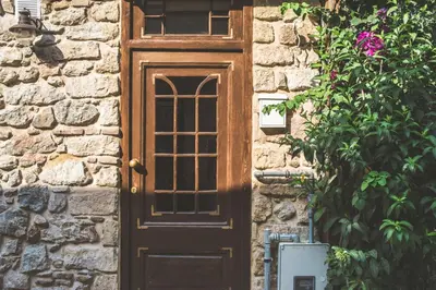 a wooden door on a stone building with a plant at Stone house near Acropolis - Living Stone Diamond in Athens