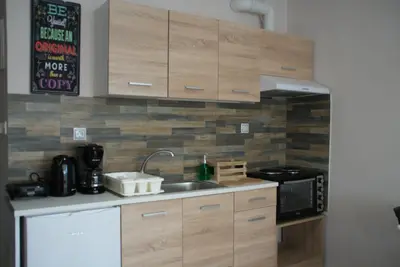 a kitchen with wooden cabinets and a sink and a microwave at The Victoria Square Apartments in Athens