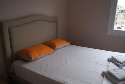 a bed with two orange pillows on top of it at The Victoria Square Apartments in Athens