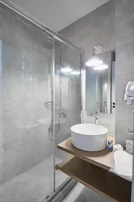 a bathroom with a white sink and a shower at Be based near Acropolis, in an exquisite studio! in Athens