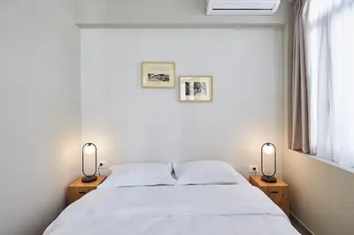 a bedroom with a white bed with two lamps at Be based near Acropolis, in an exquisite studio! in Athens