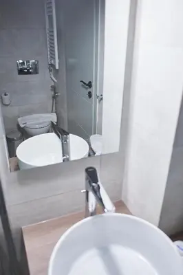 a bathroom with a sink and a toilet and a mirror at Be based near Acropolis, in an exquisite studio! in Athens