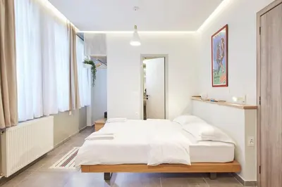 a bedroom with a large bed with white sheets at Enjoy Athens from a funky studio near Acropolis! in Athens