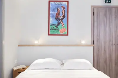 a poster of a movie hanging above a bed at Enjoy Athens from a funky studio near Acropolis! in Athens