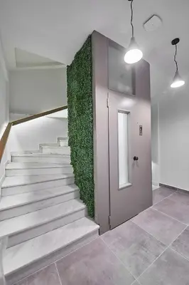 a staircase with a green wall next to a door at Enjoy Athens from a funky studio near Acropolis! in Athens