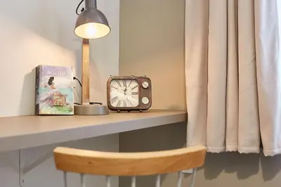 a table with a clock and a book and a lamp at Enjoy Athens from a funky studio near Acropolis! in Athens