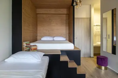 two beds in a small room with wooden walls at Bespoke House Athens in Athens