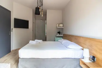 a bedroom with a white bed and a television at Bespoke House Athens in Athens