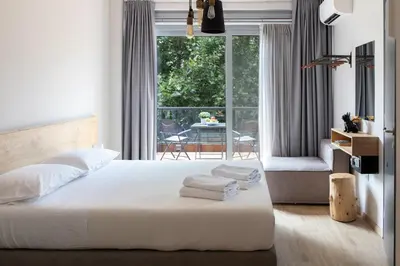 a bedroom with a white bed and a balcony at Bespoke House Athens in Athens