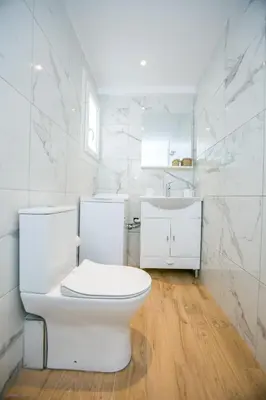 a white bathroom with a toilet and a sink at Raise comfy studios in the heart of Athens in Athens