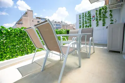 a row of chairs and a table on a balcony at Raise comfy studios in the heart of Athens in Athens