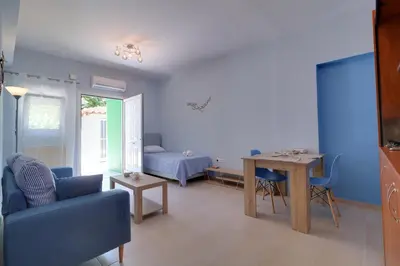 a blue living room with a table and a couch at Carpe Diem near the Athens airport in Markopoulo