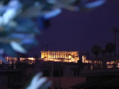 a building lit up at night with at Sophia's Penthouse Apartment With Jacuzzi and Acropolis View From Big Terrace in Athens