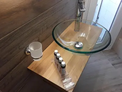 a table with a glass sink and five bottles on it at Sophia's Penthouse Apartment With Jacuzzi and Acropolis View From Big Terrace in Athens