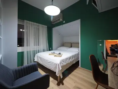 a bedroom with a bed and a green wall at Sophia's Penthouse Apartment With Jacuzzi and Acropolis View From Big Terrace in Athens