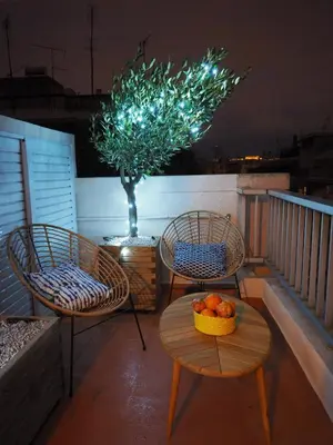 two chairs and a table with a bowl of fruit on a balcony at Sophia's Penthouse Apartment With Jacuzzi and Acropolis View From Big Terrace in Athens