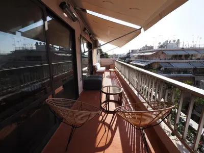 a balcony with chairs and tables on a building at Sophia's Penthouse Apartment With Jacuzzi and Acropolis View From Big Terrace in Athens