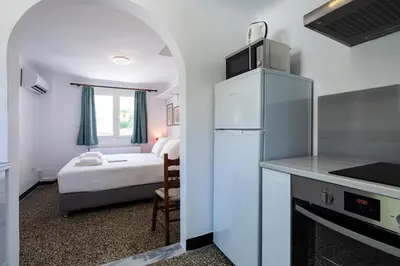 a kitchen with a refrigerator and a bedroom with a bed at Enticing, Cosy, Rooftop Studio Athens Centre! EP9T in Athens