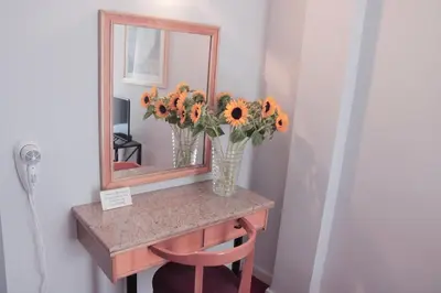 a vase of sunflowers on a table with a mirror at Hotel Victory in Athens