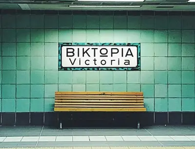 a bench in a building with a sign on a wall at Hotel Victory in Athens