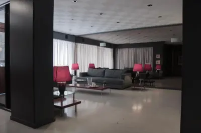 a living room with a couch and tables and red lamps at Hotel Victory in Athens