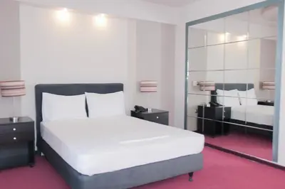 a bedroom with a large white bed and a mirror at Hotel Victory in Athens