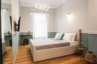 a bedroom with a bed in a room with a window at Step One | Luxury Suites right in the heart of Acropolis next to metro station in Athens
