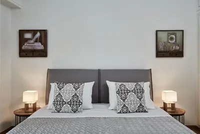 a bedroom with a bed with pillows and two lamps at Chic One Bd Apartment with Hilton View in Athens