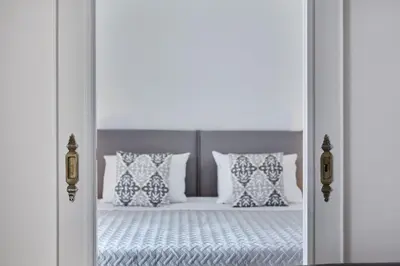 an open door to a bedroom with a bed with pillows at Chic One Bd Apartment with Hilton View in Athens