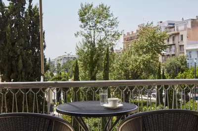 a table with a cup and a glass on a balcony at Chic One Bd Apartment with Hilton View in Athens