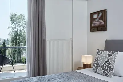 a bedroom with a bed and a large window at Chic One Bd Apartment with Hilton View in Athens