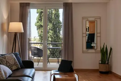 a living room with a couch and a sliding glass door at Chic One Bd Apartment with Hilton View in Athens