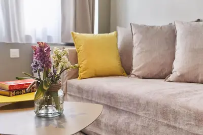 a vase of flowers on a table in a living room at Walk through Athens from 1-bdr next to Acropolis! in Athens
