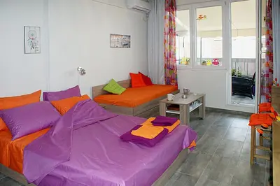a bedroom with two beds and a table in it at Sunny studio with Parthenon view balcony in Athens