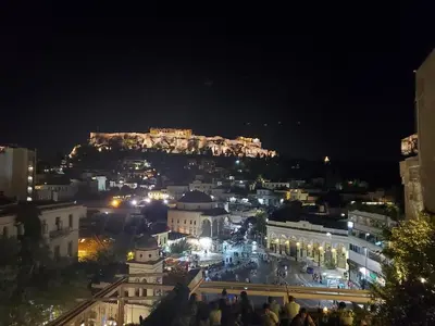 a view of a city at night with the acropolis at Sunny studio with Parthenon view balcony in Athens