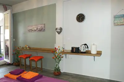 a room with a counter and two stools and a table at Sunny studio with Parthenon view balcony in Athens