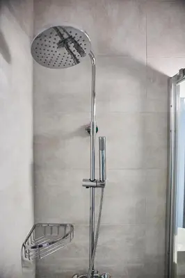 a shower with a shower head in a bathroom at Explore Athens from an uber-central studio! in Athens