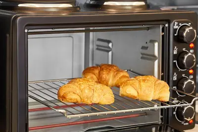 three croissants sitting on a rack in a toaster oven at Live in a funky & renovated studio near Acropolis in Athens