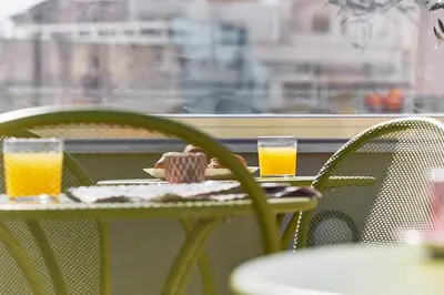 a table with two glasses of orange juice on it at Live in a funky & renovated studio near Acropolis in Athens