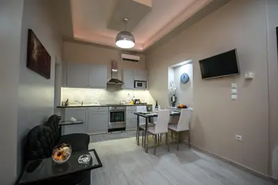 a living room and kitchen with a table and chairs at ARETI in Athens