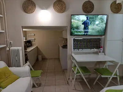 a living room with a table and a tv on the wall at The Urban Escape in Athens