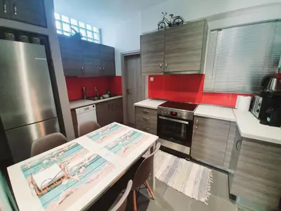 a kitchen with wooden cabinets and a table in it at Ilias' cosy and relaxing apartment in Athens