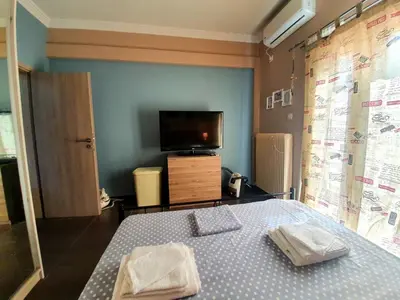 a bedroom with a bed and a flat screen tv at Ilias' cosy and relaxing apartment in Athens