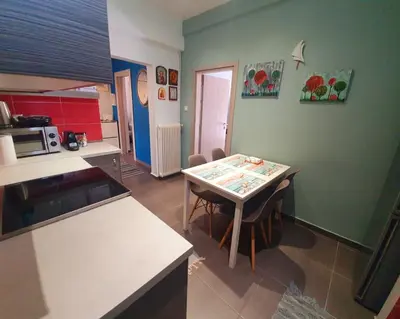 a kitchen with a table and chairs in a room at Ilias' cosy and relaxing apartment in Athens