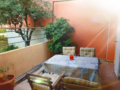 a patio table and chairs on a balcony with trees at Ilias' cosy and relaxing apartment in Athens