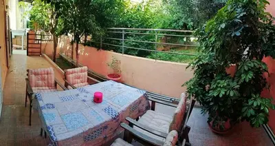 a table and chairs on a balcony with plants at Ilias' cosy and relaxing apartment in Athens