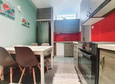 a kitchen with a table and chairs in it at Ilias' cosy and relaxing apartment in Athens