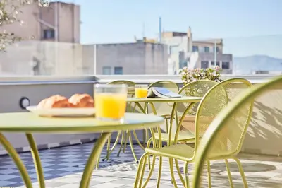 two tables and chairs on a balcony with orange juice at Stay in a hip decorated studio near Acropolis! in Athens