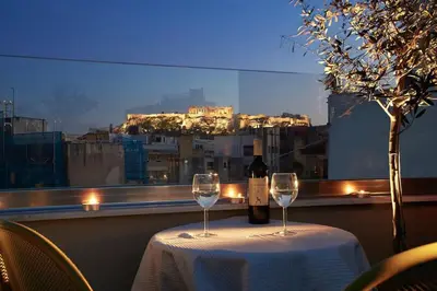 a table with a bottle of wine and two glasses at Mind-blowing petite studio in the heart of Athens! in Athens